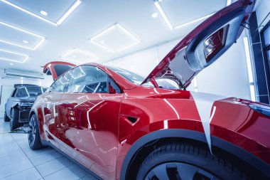 Yeni kırmızı arabaya koruyucu film yükleme işlemi