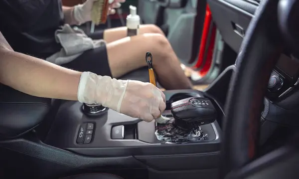 年轻女子用一种特殊的泡沫刷子擦拭汽车内部 — 图库照片