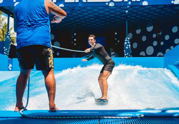 Młody Człowiek Surfujący Trenerem Symulatorze Fali Parku Rozrywki Wodnej — Zdjęcie stockowe