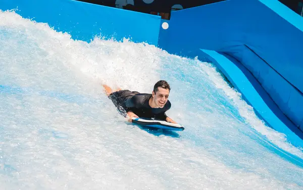 Młody Człowiek Surfujący Symulatorze Fali Parku Rozrywki Wodnej — Zdjęcie stockowe