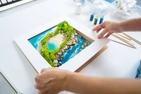 The process of making the art decor of epoxy resin, natural stones and moss.