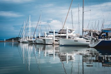 Birçok beyaz modern yatlar marinaya demirlemişti.