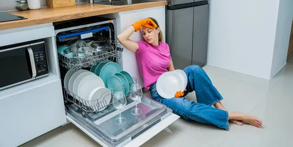 Молодая Женщина Сидит Полу Возле Посудомоечной Машины — стоковое фото