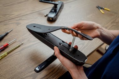 Bir teknisyen ev koruması için akıllı elektronik kapı kilidi kurar ve monte eder..