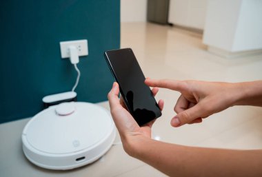 Evde bir robot elektrikli süpürge şarj istasyonuna doğru ilerliyor.