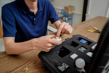 Bir teknisyen akıllı ev sisteminin demo kiti ile çalışır..