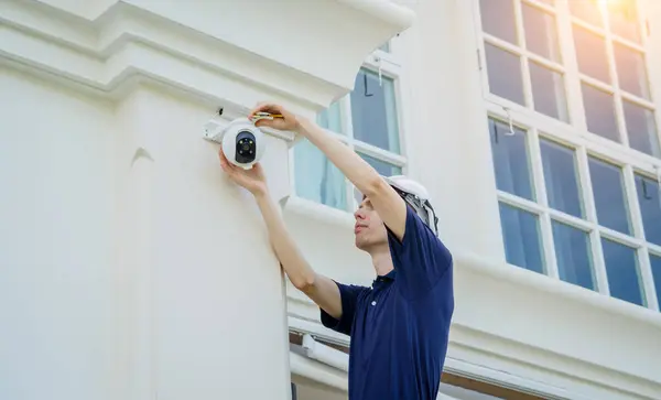 技術者は 住宅ビルの正面にCctvカメラをインストールします — ストック写真