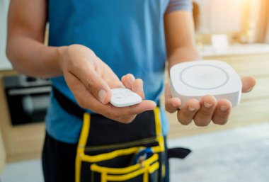 Bir teknisyen modern bir daireye güvenlik alarmı yerleştiriyor.