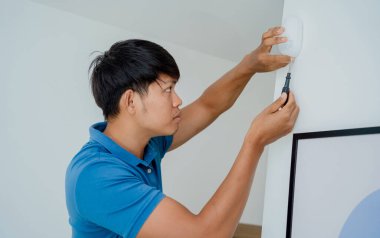 Modern bir daireye hareket sensörü yerleştiren bir teknisyen.