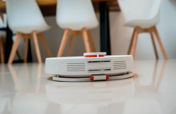 A robot vacuum cleaner at home moving towards the charging station