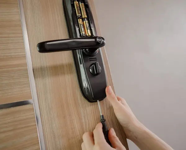 技術者は木製のドアに現代スマートなドア ロックを取付けます — ストック写真