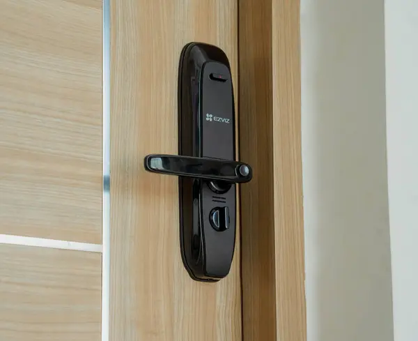 Modern smart door lock on the wooden door in a cozy apartment.