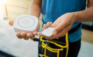 Bir teknisyen modern bir daireye güvenlik alarmı yerleştiriyor.