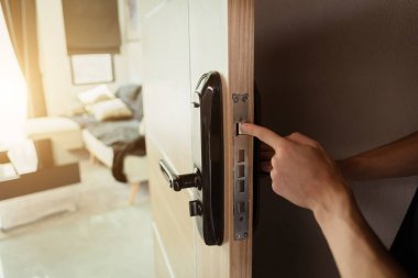 Bir teknisyen ahşap kapıya modern bir kapı kilidi takıyor..