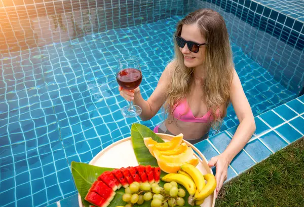 Schöne Frau Schwimmbad Mit Einem Glas Wein Und Einem Schwebenden lizenzfreie Stockbilder