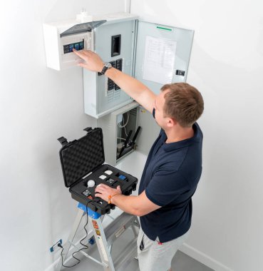 Bir teknisyen akıllı ev sisteminin demo kiti ile çalışır..