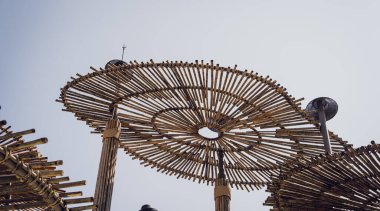 Açık mavi gökyüzünün zeminine kurulmuş ahşap şemsiyeler..