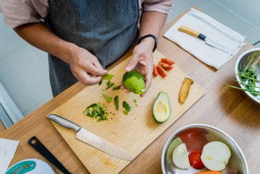 Şef mutfakta avokadoyla sağlıklı kinoa kasesi hazırlıyor..