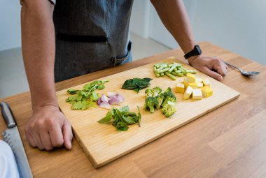 Aşçı mutfakta yeşil köri hazırlıyor otlar ve pirinçle.