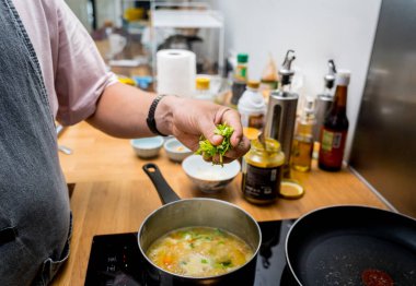 Şef mutfakta karnabahar ve brokoliyle mercimek çorbası hazırlıyor..