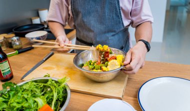Şef mutfakta baharatlı cam erişte salatası hazırlıyor..