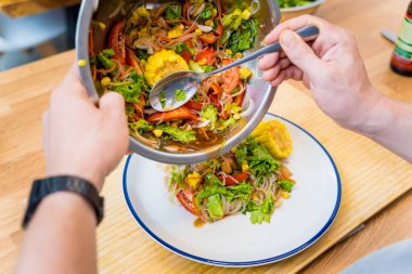 Şef mutfakta baharatlı cam erişte salatası hazırlıyor..