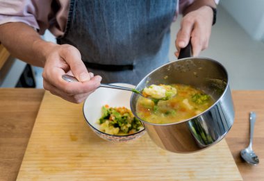 Şef mutfakta karnabahar ve brokoliyle mercimek çorbası hazırlıyor..