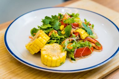 Beyaz tabakta baharatlı cam erişte salatası..