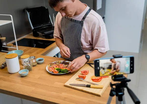 stock image The chef is broadcasting live from workshop how to prepare a grilled eggplants with garlic.