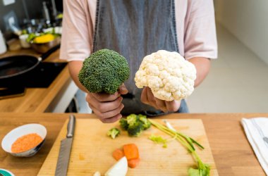 Şef mutfakta karnabahar ve brokoliyle mercimek çorbası hazırlıyor..