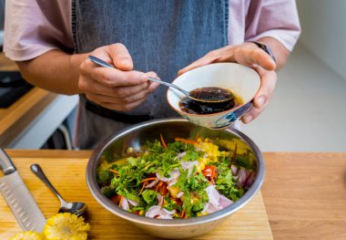 Şef mutfakta baharatlı cam erişte salatası hazırlıyor..