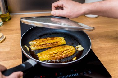 Şef mutfakta ızgara patlıcan ve sarımsak hazırlıyor..