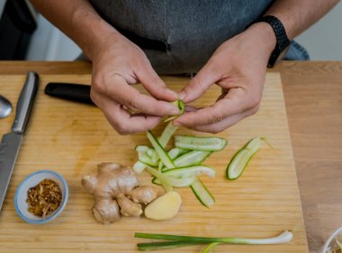 Aşçı mutfakta soğan ve susamlı pirinç lapası hazırlıyor..