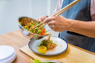 Şef mutfakta baharatlı cam erişte salatası hazırlıyor..