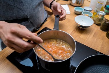 Şef mutfakta karnabahar ve brokoliyle mercimek çorbası hazırlıyor..