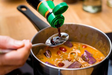 Şef mutfakta tatlı patates ve baharatlı masör körisi hazırlıyor..