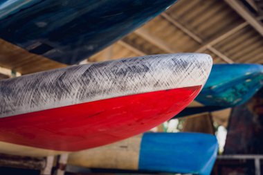 Çeşitli sörf tahtaları tezgahta düzgünce sergileniyor..