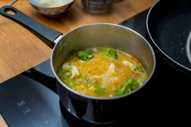 Şef mutfakta karnabahar ve brokoliyle mercimek çorbası hazırlıyor..