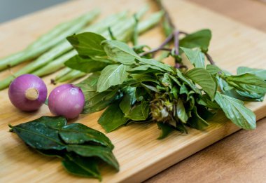 Yeşil köri, şifalı otlar ve pirinçle hazırlamak için malzemelerle tahta kesmek..
