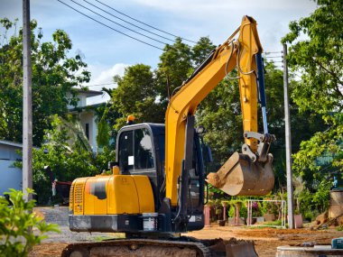İnşaat alanında büyük bir kazıcı çalışıyor.,