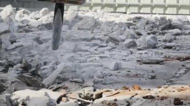 Bir kazıcı inşaat başlamadan önce beton bir asfalt katmanını yıkar.