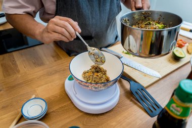 Şef mutfakta avokadoyla sağlıklı kinoa kasesi hazırlıyor..