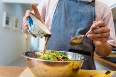 Şef mutfakta baharatlı cam erişte salatası hazırlıyor..