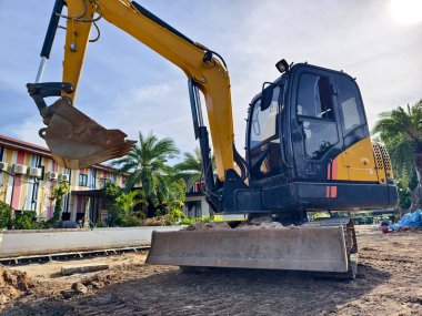 İnşaat alanında büyük bir kazıcı çalışıyor.,