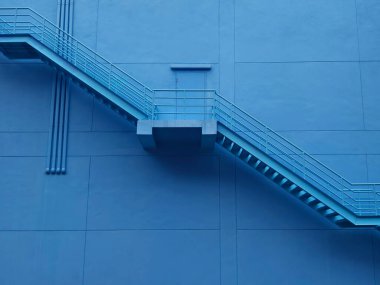 Büyük mavi bir duvara tırmanan bir merdiven seti..