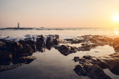 Okyanus dalgalarıyla çevrili büyük bir kaya..