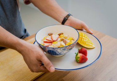 Şef mutfakta yulaf, çilek ve mango hazırlıyor..