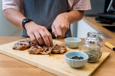 Şef mutfakta ev yapımı elektrikli ızgarada biftek hazırlıyor..