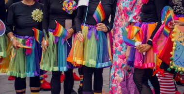 Gökkuşağı bayrağı taşıyan ve gökkuşağı etek giyen insanlar gururla görülüyor..