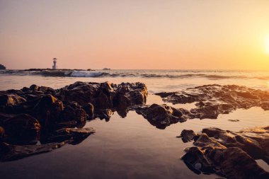 Okyanus dalgalarıyla çevrili büyük bir kaya..